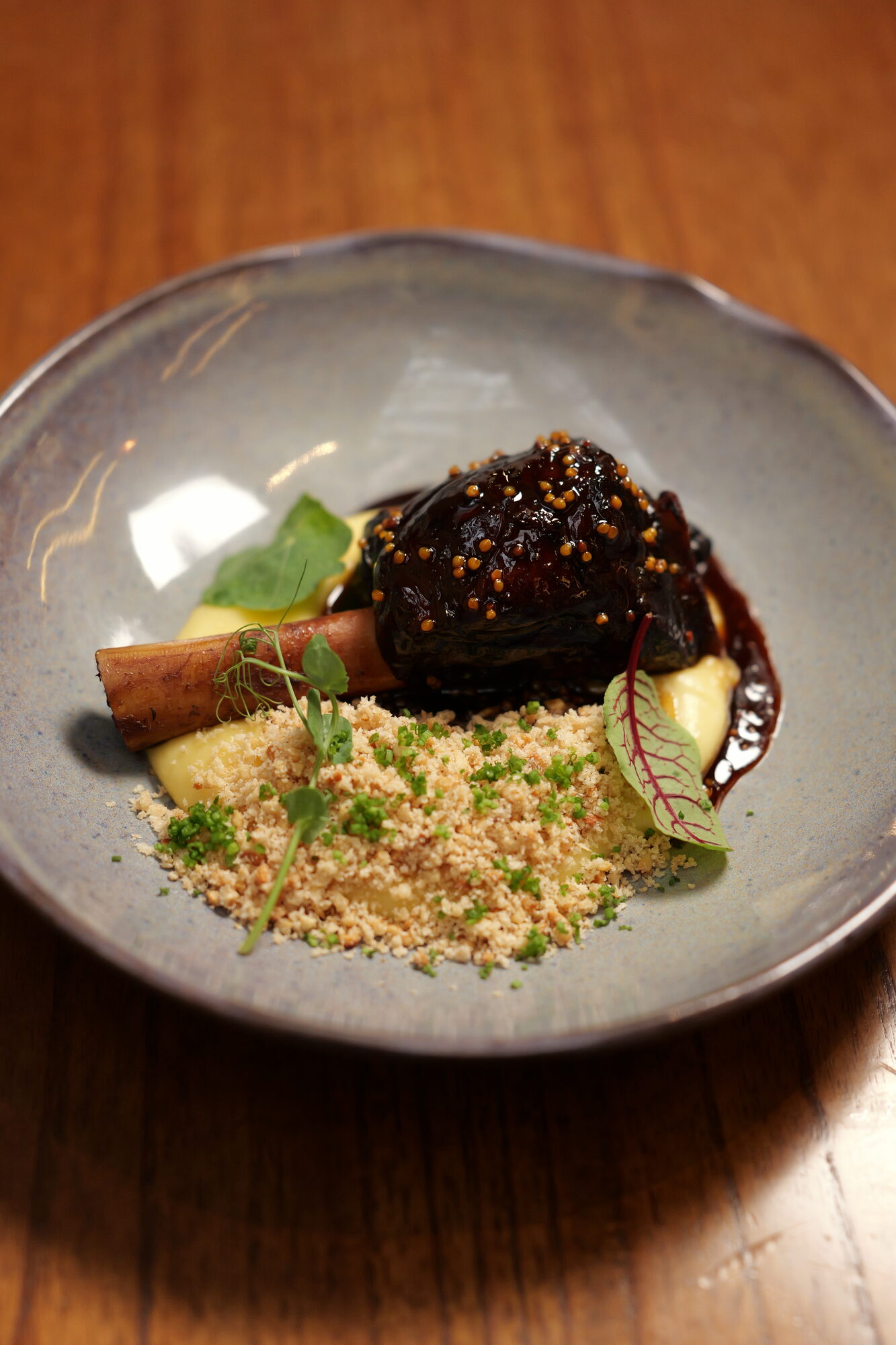 Carne braseada envidraçada com caviar de mostarda, purê e farofa de castanha