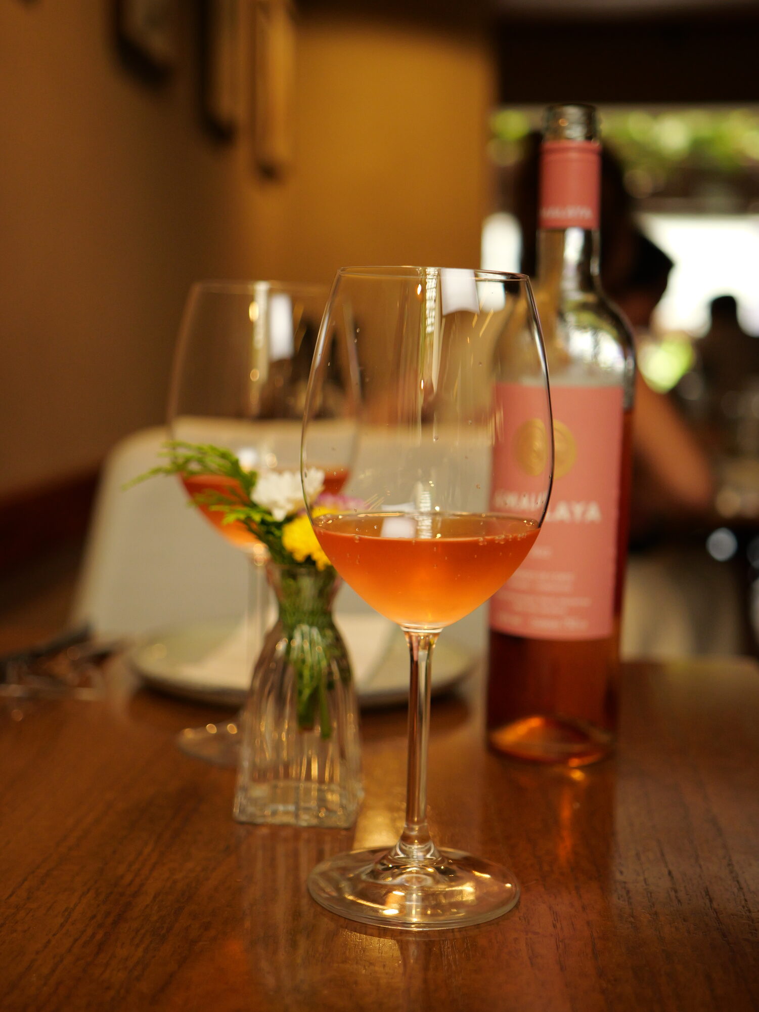 Taça de vinho laranja servida na mesa do salão